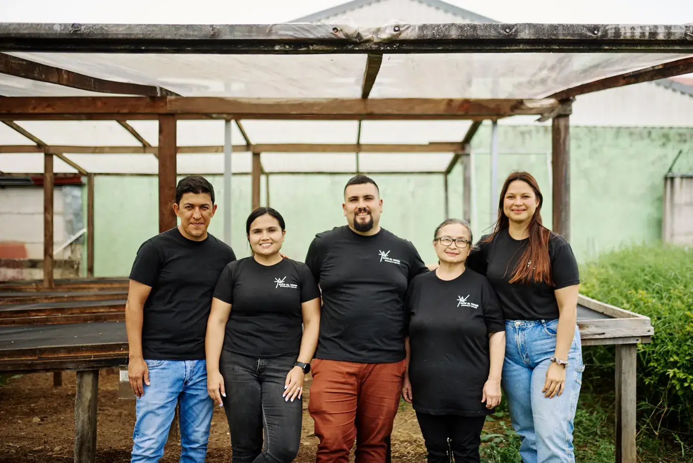 La familia de Alto el Vapor delante de las camas de secado